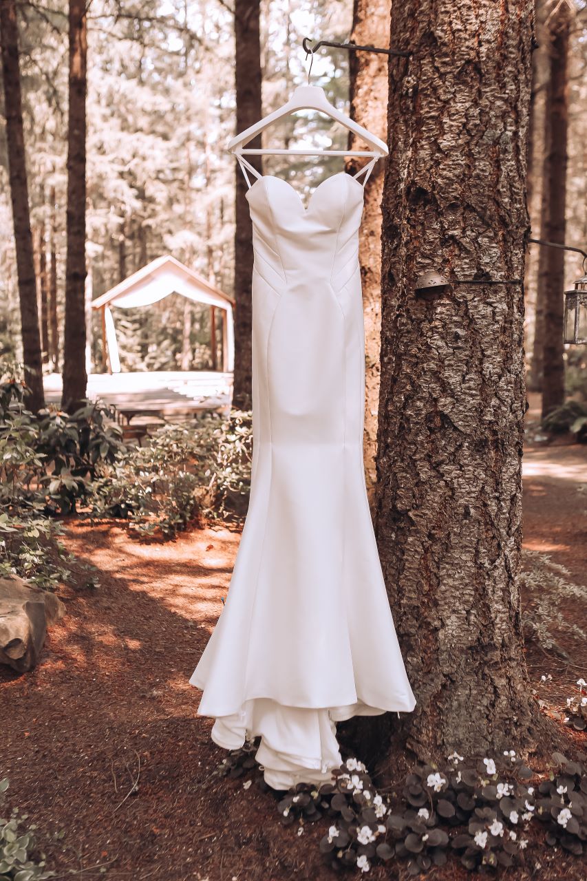 A wedding gown hanging from a tree at Three Strands Farm
